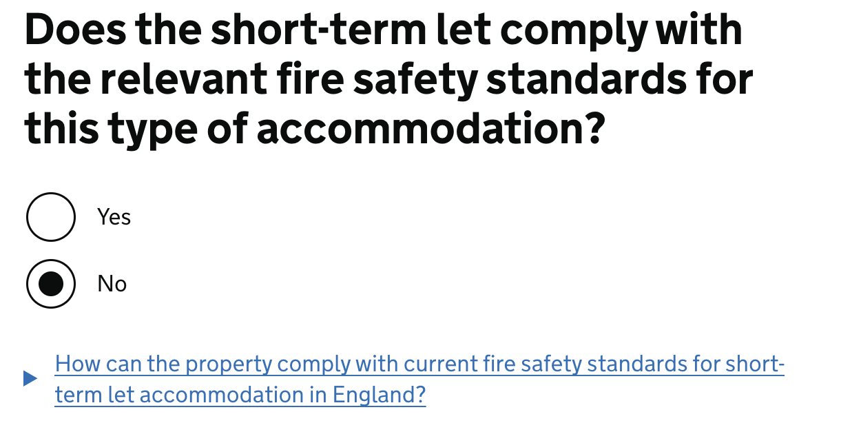 Screenshot of a page showing a heading that reads: ‘Does the short-term let comply with the relevant fire safety standards for this type of accommodation?’. Beneath this there are two radio buttons that have a “yes” and “no” option. The “No” radio button is checked. Beneath this there is a details component that reads “ How can the property comply with current fire safety standards for short-term let accommodation in England?”.